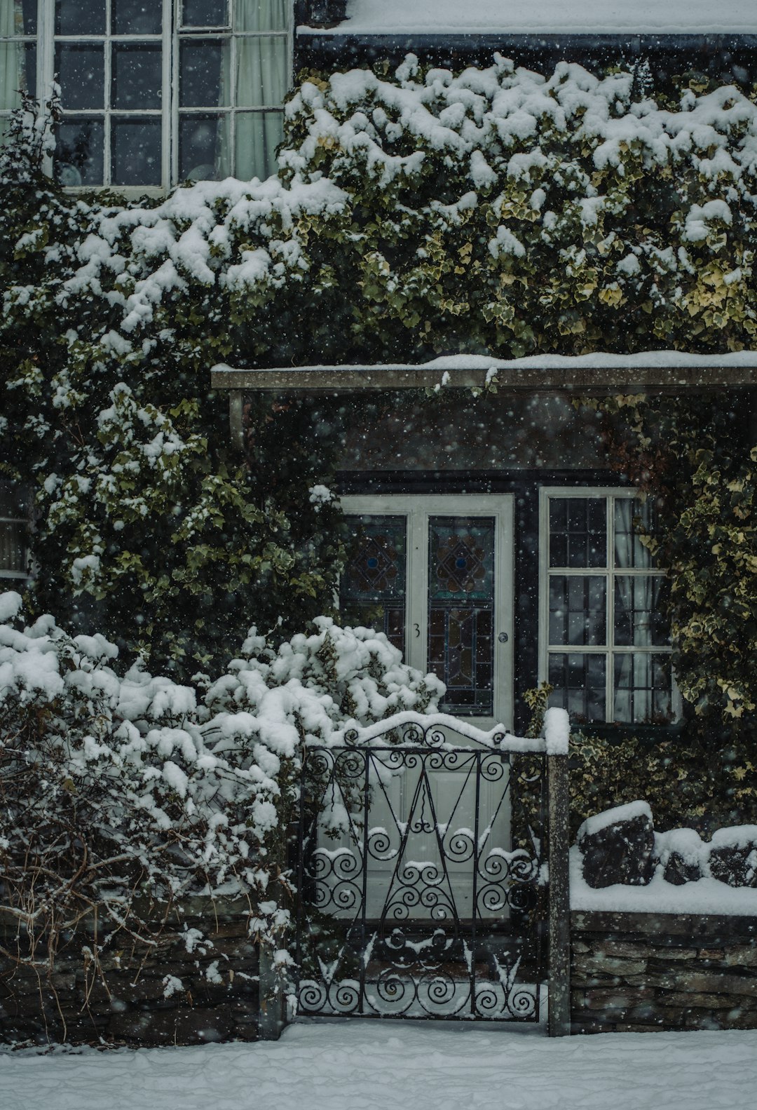 Snow-covered cottage with gate in a winter Lake District scene